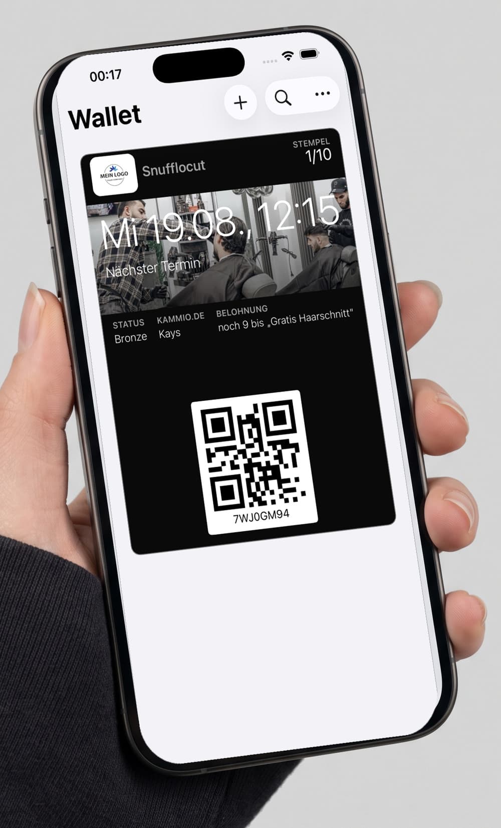 Eine Hand hält ein Handy, auf dem die digitale Treuekarte des Demo-Salons Snufflocut im Apple Wallet liegt — mit Stempelstand, nächstem Termin und Belohnung.